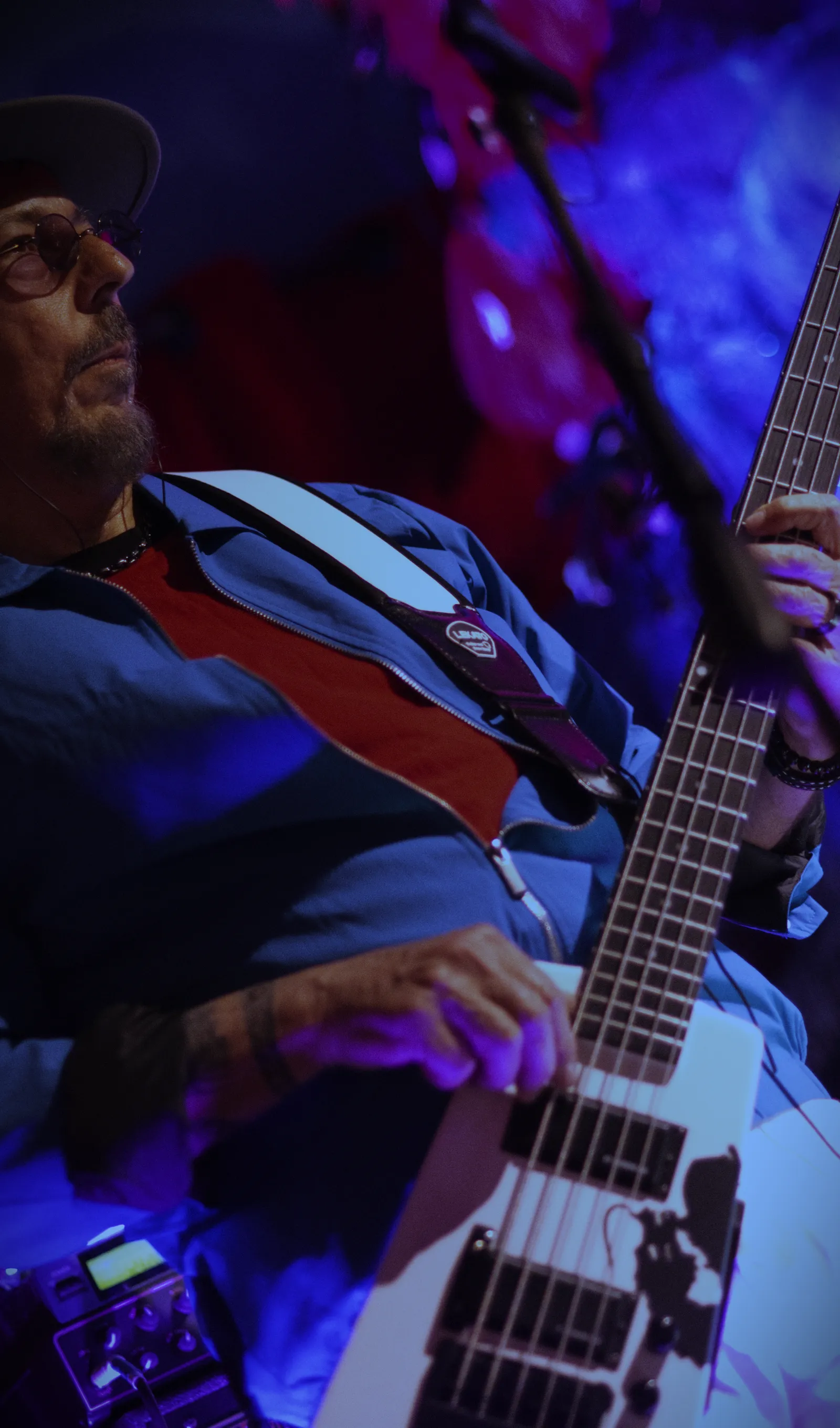 Notorious bassist playing under blue stage lights