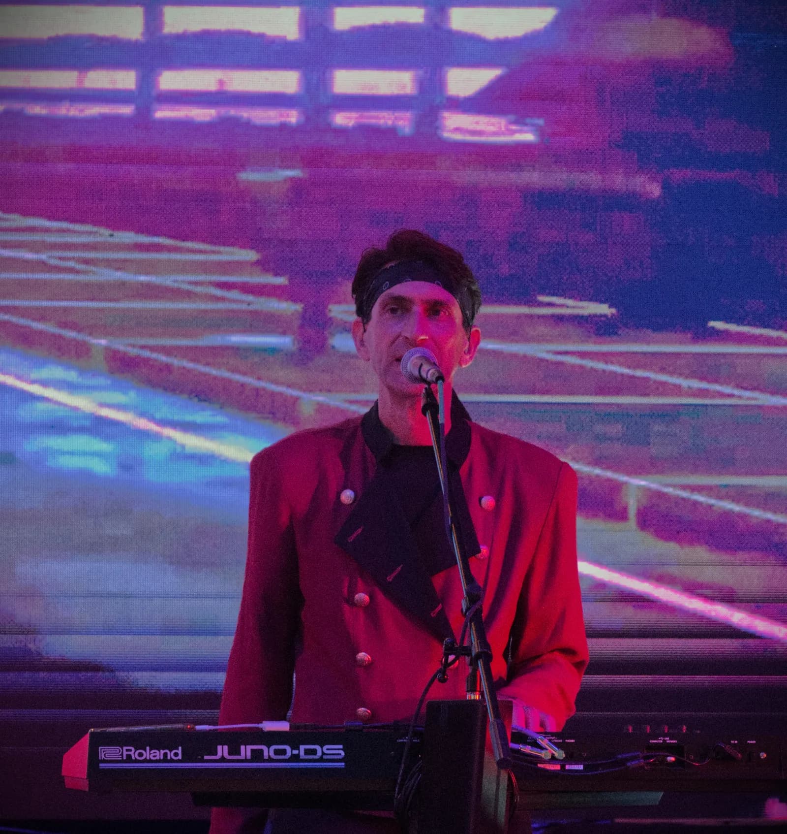Notorious keyboardist singing in a red jacket