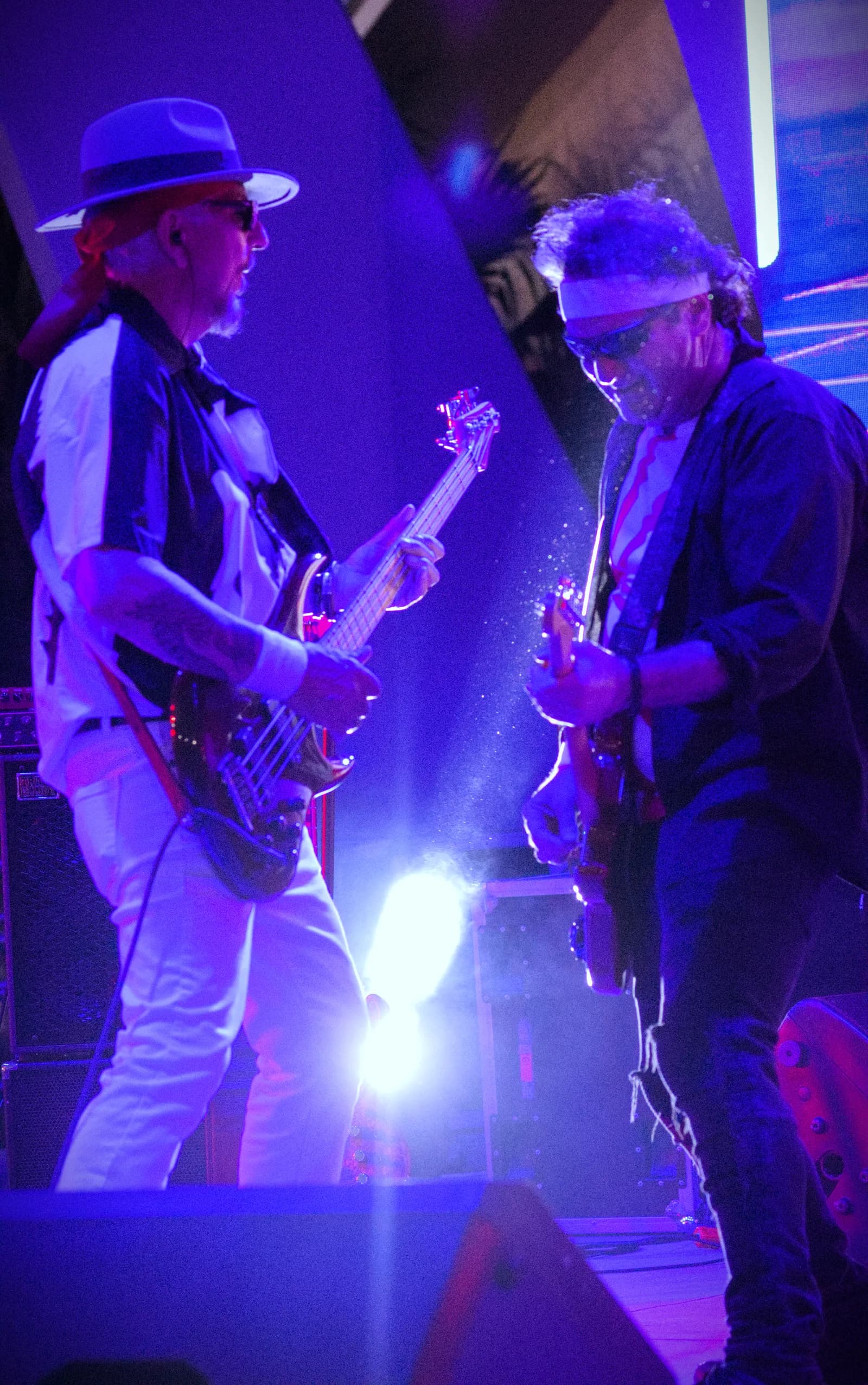 Notorious bassist and guitarist facing off in a spotlight